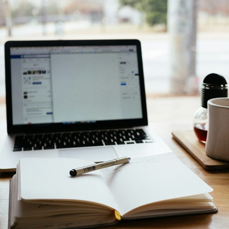 Laptop mit Notizbuch und Stift davor liegend – Workshops rund ums Baby